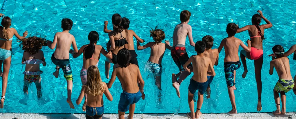 Escolars saltant a la piscina
