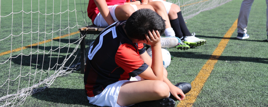 Nen a la banqueta en un partit de futbol 7