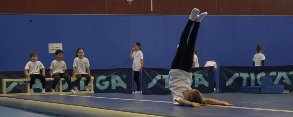 Gimnasta escolar fent exercici de tumbling de trampolí