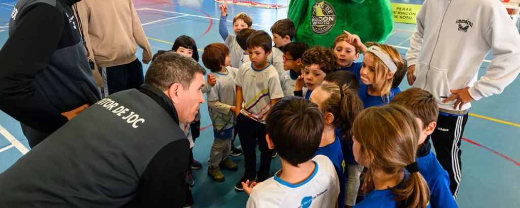 Tutor de joc explicant a un equip escolar